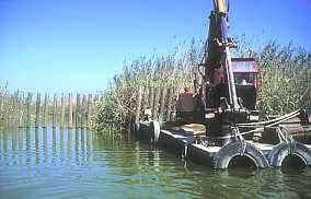 Imagen realizada el 11 de septiembre de 1999. Máquinas con flotadores son utilizadas para taponar los canales. 